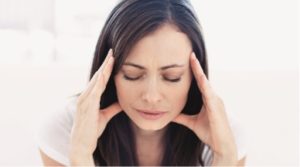 Woman enduring a headache touching her head